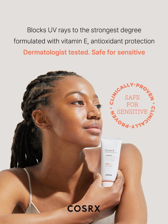 Model holding COSRX Vitamin E Vitalizing Sunscreen SPF 50+, captioned ‘Dermatologist Tested Safe for Sensitive Skin’; clinically proven K-beauty SPF that blocks UV rays, nourishes with vitamin E, and creates a hydrating, non-white-cast base ideal for daily wear under makeup.