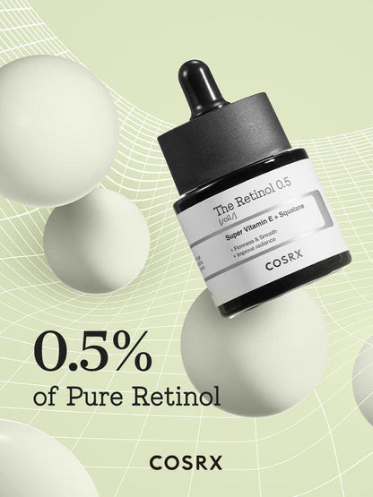 Minimalist display of COSRX The Retinol 0.5 Oil bottle labeled 0.5% pure retinol; high-strength Korean retinol formula with vitamin E and squalane to improve fine lines and texture while protecting skin barrier from dryness and irritation.